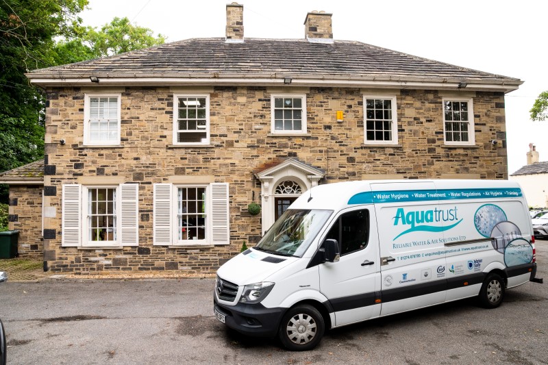 aquatrust van parked outside building