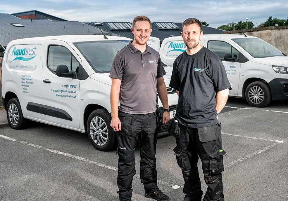 Our-Own-Team Aquatrust employees in front of branded vans